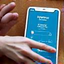 Hands of different ages and abilities interacting with a tablet showing a wellness app